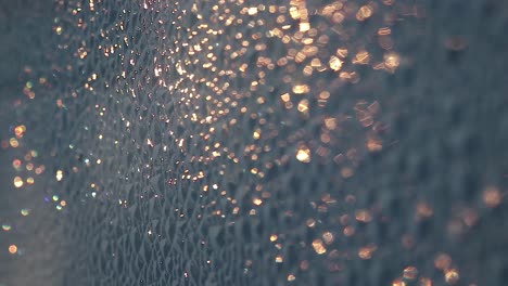Close-up-of-golden-bokeh-glowing-on-a-rough-surface-during-a-summer-sunrise