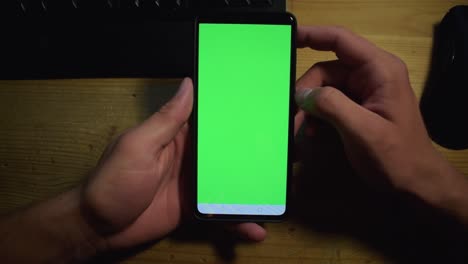 Young-adult-boy-hold-smartphone-with-a-greenscreen-in-his-hands-16