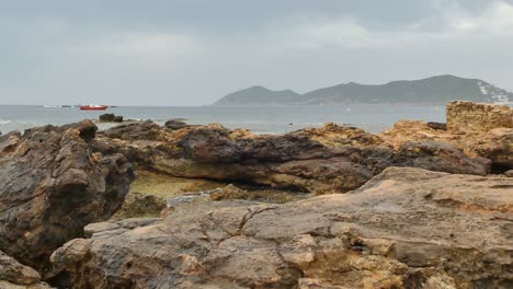Ein-Schöner-Blick-Auf-Die-Felsige-Küste-Von-Ibiza-Mit-Den-Wellen,-Die-Sich-An-Den-Felsen-Brechen