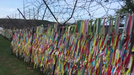 Ribbons-of-hopes-hang-at-barbed-wire-fence-at-Imjingak-by-the-DMZ-overlooking-North-Korea,-in-Munsan,-Paju,-Gyeonggi-do,-South-Korea