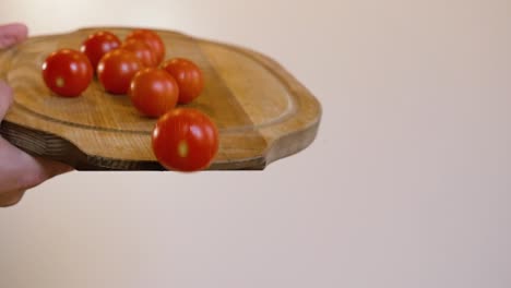 Tomates-Rodando-De-Una-Tabla-De-Cortar-De-Madera