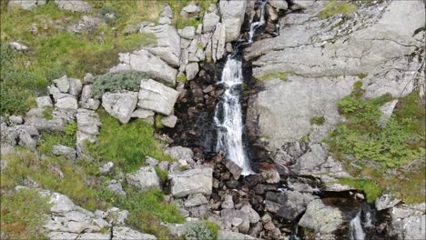Waterfall-drone-shot-following-the-water-down-the-mountain