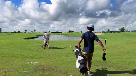 Junge-Und-Mann,-Die-An-Einem-Sonnigen-Tag-Gemeinsam-Auf-Dem-Grünen-Golfplatz-Spazieren-Gehen