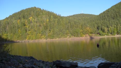 Malerischer-Blick-Auf-Einen-Großen-See-Mit-Reflexion-über-Das-Wasser-Und-Die-Hügel-Im-Hintergrund-Im-Herbst