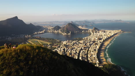 Aerial-Around-Hikers-At-Mountain-Top-Revealing-City-Of-Rio-De-Janeiro