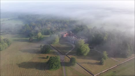 Großes-Herrenhaus,-Das-Von-Nebel-Und-Nebel-Bedeckt-Ist,-Der-Von-Einer-Drohne-Geschossen-Wurde
