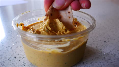 Pitta-bread-dipped-into-houmous-dip.-Food