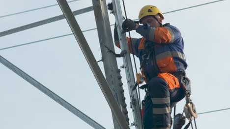 Maintenance-repair-man-climbs-up-high-electrical-pole