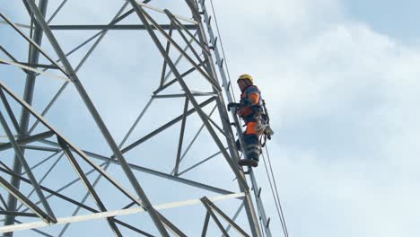Electrician-climbs-up-pylon,-secured-with-a-rope