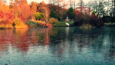 Gefrorener-See-Bedeckt-Mit-Blättern-Und-Herbstbaumfarbreflexionen