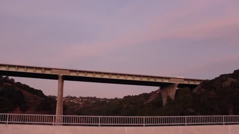 Pan-of-a-towering-bridge-during-a-beautiful-Northern-California-Sunset