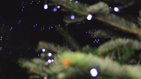 Fokus-Ziehen,-Weihnachtsbaumzweige-Aus-Nächster-Nähe-Mit-LED-Lichterketten-Und-Bokeh