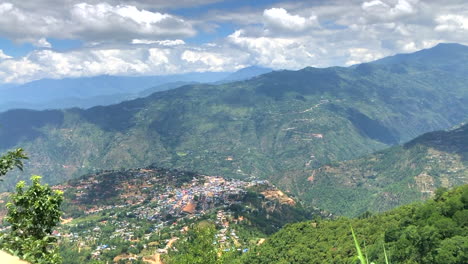 Day-timelapse-of-clouds-moving-over-a-small-valley-city-of-Phidim-in-Panchthar,-Nepal-surrounded-by-hills-on-all-sides
