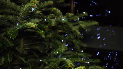 Toma-Estática-Del-árbol-De-Navidad-Con-Luces-De-Cadena-LED-Reflejadas-En-El-Fondo-De-La-Ventana-Y-Tirador-De-Enfoque