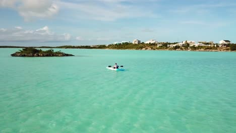 Young-guy-paddling-a-kayak-in-the-ocean-off-the-coast-of-Providenciales-in-the-Turks-and-Caicos-archipelago