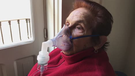 Mittlere-Aufnahme-Einer-älteren-Kaukasischen-Frau,-Die-Zu-Hause-Medikamente-Aus-Einem-Vernebler-Inhaliert