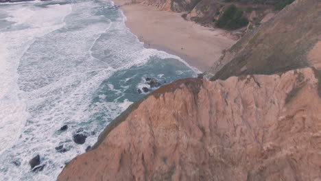 Cliff-Side-Beaches-with-Pacific-Waves-Crashing-Below-Winter-Sunset-Aerial-Flight