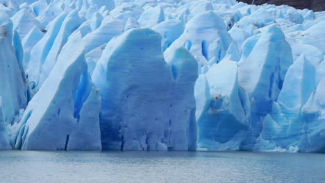 Glaciar-Azul-Derritiéndose-Lentamente-En-Un-Lago-Gris