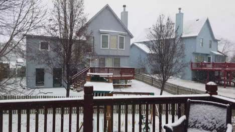 Snow-falling-in-a-backyard-looking-out-from-deck