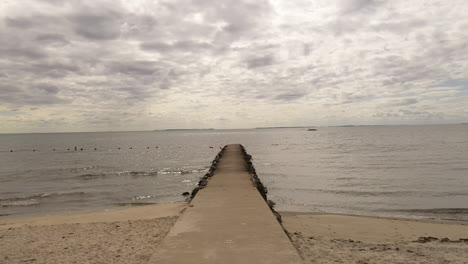 View-going-down-a-pier-on-a-cloudy-day-in-West-Beach-Connecticut-slow-push