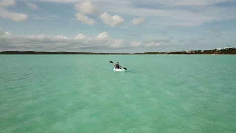 Low-flying-aerial-of-a-kayaker-in-the-ocean-off-coast-of-Providenciales-in-the-Turks-and-Caicos-archipelago