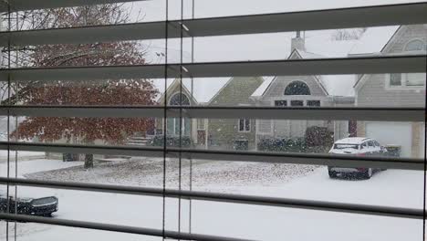 Slow-motion-snow-falling-looking-through-window-and-blinds