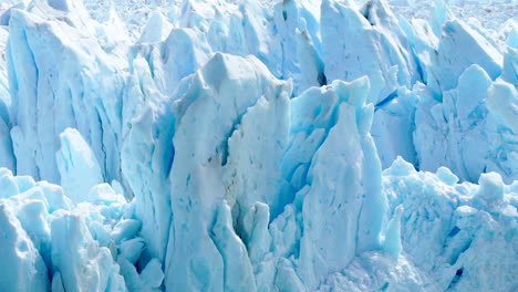 Blue-glacier-melting-in-sunlight,-close-up