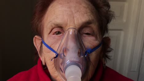 Dolly-out-from-the-face-of-an-elderly-caucasian-woman-receiving-a-nebulizer-treatment