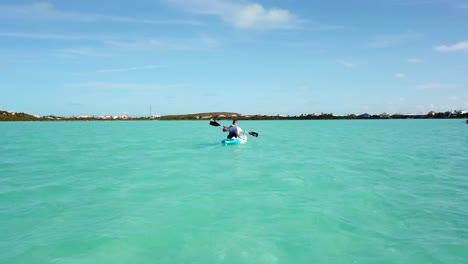 Kayaker-in-the-turquoise-blue-ocean-off-the-coast-of-Providenciales-in-the-Turks-and-Caicos-archipelago