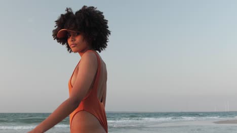 Young-girl-with-curly-afro-hair-walking-on-a-beach