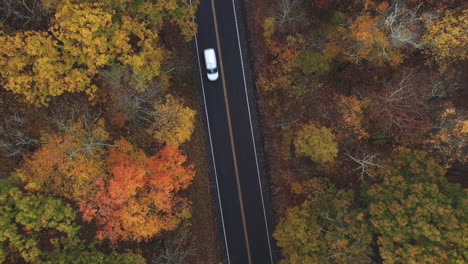 Drone-flying-over-two-lane-highway-in-New-England-in-the-fall-with-leaves-changing-colors-1