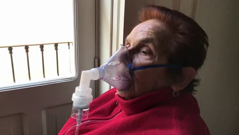 Elderly-woman-receiving-respiratory-tract-treatment-at-home-in-slow-motion