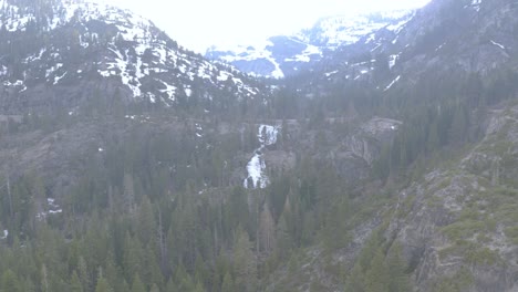 View-of-the-mountain-covered-by-snow-and-waterfall-in-the-center-of-the-frame