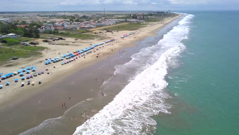 Drone-shot-flying-down-over-the-beach-in-the-town-of-Playas-General-Villamil,-Ecuador