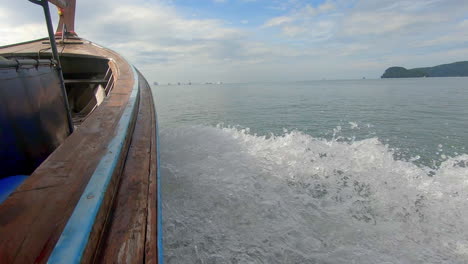 SLOW-MOTION-|-Wake-coming-off-wooden-boat-in-Thailand-with-islands-in-the-distance