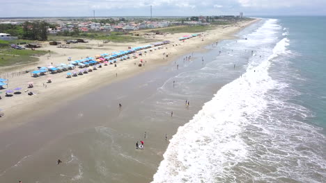 Drone-shot-flying-over-the-beach-in-the-town-of-Playas-General-Villamil,-Ecuador