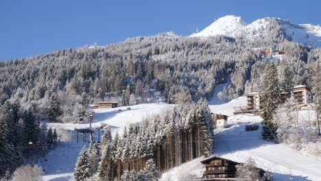 Alpine-mountain-slope-with-a-hotel-and-gondolas-operating-in-a-clear-winter-day