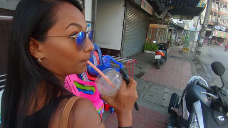 SLOW-MOTION-|-Indian-woman-walking-down-the-street-in-Asia-drinking-from-a-straw