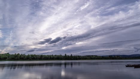 White-gray-clouds-torn-by-the-wind-in-different-directions-rushing-above-the-waters-of-Namsen-river