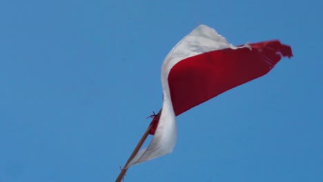 Indoensian-flag-swaying-in-wind-on-clear-blue-day