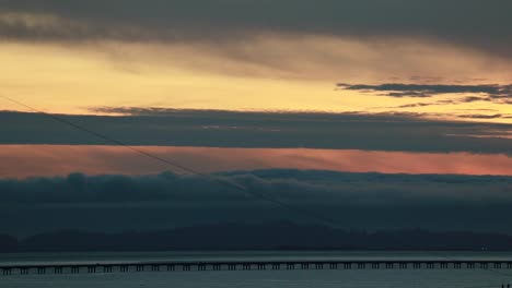 Time-lapse-Dusk-along-the-straight-low-section-of-Astoria-Megler-bridge-Oregon-to-Washington-slow-moving-clouds-through-center