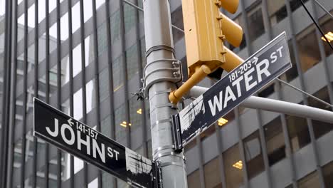 Water-St-and-John-St-signs-in-the-Financial-district,-downtown-New-York-City-during-the-Winter