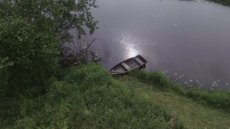 Ein-Leeres-Holzboot-Auf-Einem-Gewundenen-Fluss-An-Einem-Bewölkten-Sommertag