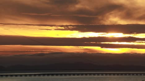 Time-lapse-sunset-along-the-straight-low-section-of-Astoria-Megler-bridge-Oregon-to-Washington-slow-moving-clouds-through-center