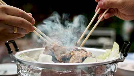 Using-chopsticks-for-BBQ-grilled-pork-or-Moo-Kra-ta-1