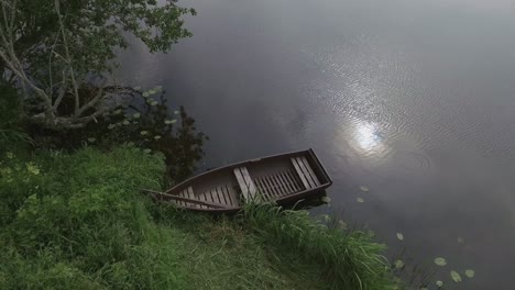 Ein-Leeres-Holzboot-Auf-Einem-Gewundenen-Fluss-An-Einem-Bewölkten-Sommertag-1