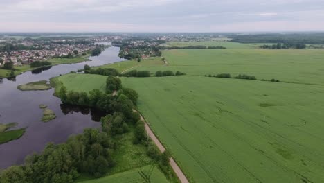 Ein-Fluss,-Der-Sich-Zwischen-Grünen-Feldern-Und-Einer-Siedlung-Windet