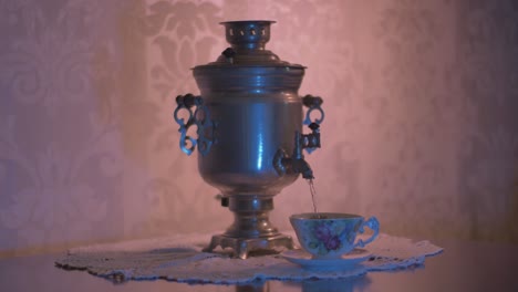 Gießen-Sie-Heißes-Wasser-Aus-Einem-Sowjetischen-Vintage-Samowar-Elektro-Metall-Teekessel-In-Eine-Wunderschöne-Tasse-1