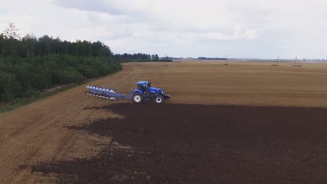 Blauer-Moderner-Pflügender-Traktor,-Der-Auf-Dem-Feld-Arbeitet