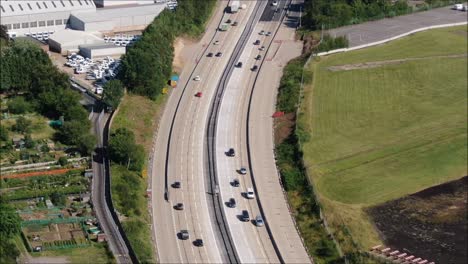 Busy-motorway-aerial-drone-tracking-shot-showing-cars-and-trucks-on-the-M27